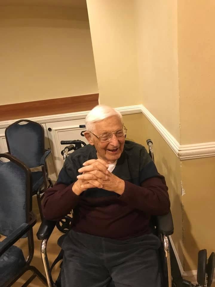 A client laughing, hands clasped, in the community room