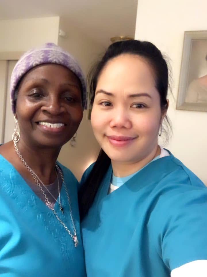 Two caregivers in matching teal scrubs