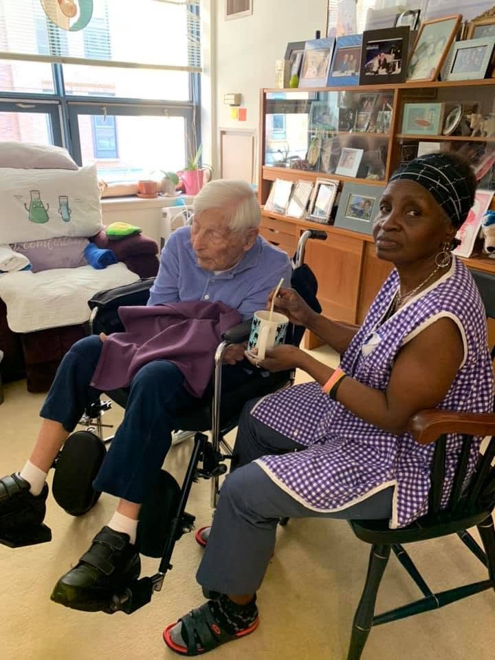 A caregiver and a client sitting together in a sunlit apartment